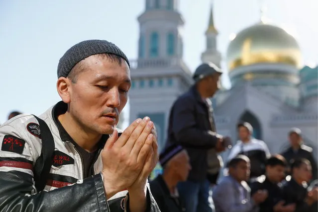 Muslims during celebrations of Eid al-Fitr, a holiday that marks the end of Ramadan, outside the Moscow Cathedral Mosque in Moscow, Russia on June 15, 2018. (Photo by Artyom Geodakyan/TASS)