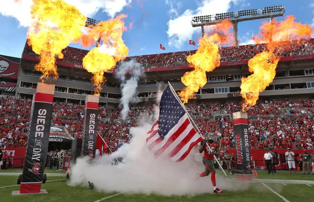 Tampa Bay Buccaneers linebacker Orie Lemon (45) carries an American flag as he runs onto the field during team introductions before an NFL football game against the New Orleans Saints Sunday, December 13, 2015, in Tampa, Fla. (Photo by Chris O'Meara/AP Photo)