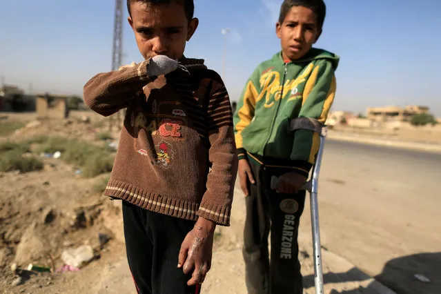 Bachir, 8, who lost his hand and one eye after a shell landed inside his house, stands with his brother Machaal, 11, who was also injured on the same day, as they are pictured at the Iraqi Special Forces checkpoint in Kokjali, east of Mosul, Iraq November 12, 2016. (Photo by Zohra Bensemra/Reuters)