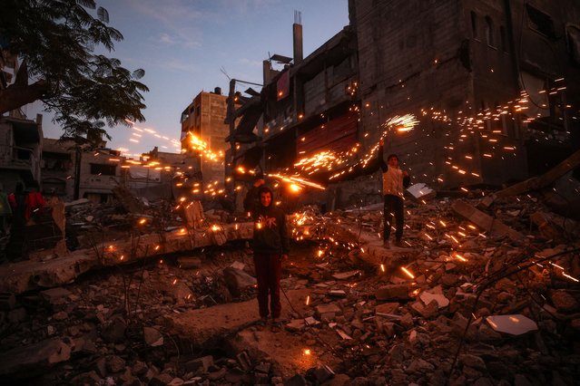 Children play with fireworks at the Bureij camp for displaced Palestinians on December 30, 2024, amid the continuing war between Israel and the militant Hamas group. Since the war between Israel and Hamas began in October last year, Gaza's 2.4 million residents have endured severe shortages of electricity, drinkable water, food and medical services. (Photo by Eyad Baba/AFP Photo)