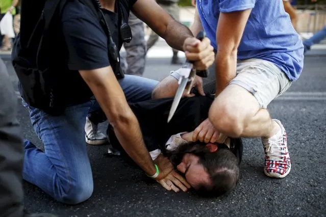 People disarm an Orthodox Jewish assailant shortly after he stabbed participants at the annual Gay Pride parade in Jerusalem July 30, 2015. (Photo by Amir Cohen/Reuters)