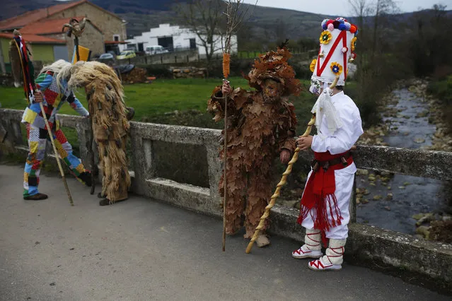 People dressed in costumes have a break while marching during the Vijanera Festival, in the small village of Silio, northern Spain, Sunday, January 3, 2016. The Vijanera masquerade, of pre-Roman origin, is the first carnival of the year in Europe symbolizing the triumph of good over evil and involving the participation of crowds of residents wearing different masks, animal skins and brightly coloured clothing with its own complex function and symbolism and becoming the living example of the survival of archaic cults to nature. (Photo by Francisco Seco/AP Photo)