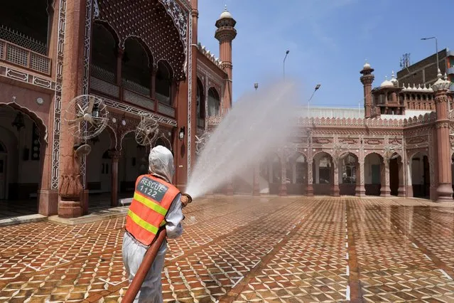 A worker sprays disinfectant to sanitize a mosque ahead of Ramadan in Peshawar, Pakistan on April 13, 2021. (Photo by Fayaz Aziz/Reuters)
