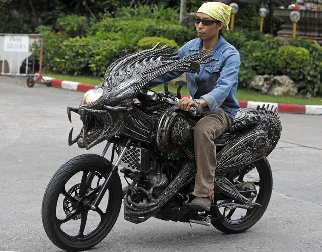 A worker drives a motorcycle made from recycled materials of spare parts from cars and bicycles at a workshop owned by Roongrojna Sangwongprisarn in Bangkok July 27, 2011. Roongrojna, 54, creates his artworks from recycled spare parts from used cars, motorcycles as well as bicycles. With four shops in Bangkok named “Ko Art Shop”, Roongrojna also exports his artworks to clients all over the world. (Photo by Sukree Sukplang/Reuters)