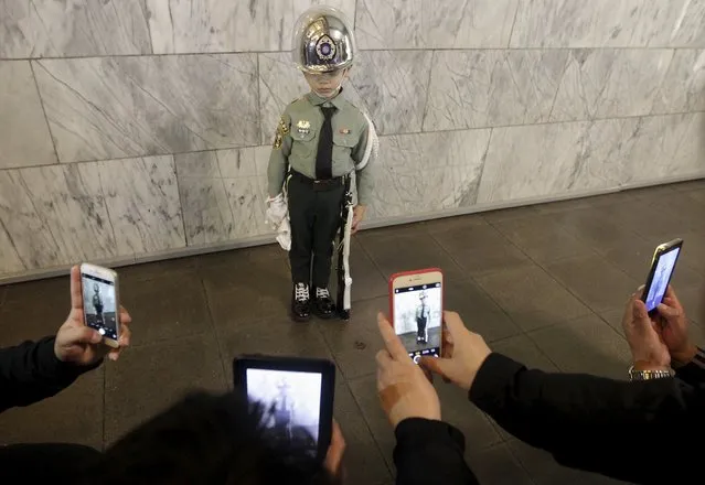 Tourists from China take pictures at a boy who is dressed up in honour guard costume at the Sun Yat-sen Memorial Hall in Taipei, Taiwan, January 12, 2016. The number of mainland Chinese tourists to neighbouring Taiwan halved in the weeks before this weekend's elections, several Taipei-based travel agencies said, as Communist Party rulers in Beijing discouraged visits to China's diplomatic rival. (Photo by Pichi Chuang/Reuters)