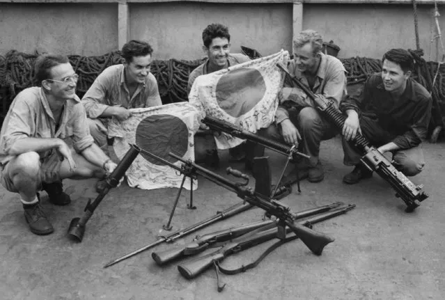 Five fighting Coast Guardsmen, who participated in the initial landing on Manus Island in the Admiralties, display Japanese trophies picked up during the swift occupation of that South Pacific stronghold. Their souvenirs include a Japanese knee mortar, flags, light machine guns, rifles, and a Japanese 25 caliber “woodpecker” on May 24, 1944. Left to right, the Coast Guardsmen are: Eric S. Wessborg, Jr., chief boatswain's mate, of Richland, Mich.; William Knight, chief quartermaster, of Oakland, Calif.; Ralph E. DeChevrieux, gunner's mate second class, of Long Beach, Calif.; John E. Schoewe, coxswain, of Milwaukee, Wis.; and Harold A. Mayer, pharmacist's mate first class, of Yankton, S.D. (Photo by AP Photo)