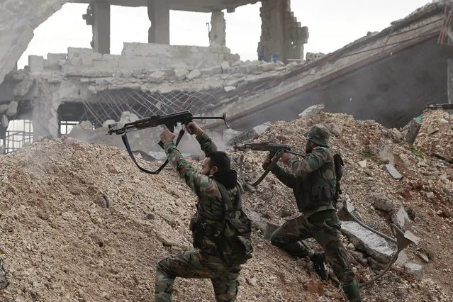 Syrian army soldiers fire their weapons during a battle with rebel fighters at the Ramouseh front line, east of Aleppo, Syria, Monday, December 5, 2016. (Photo by Hassan Ammar/AP Photo)