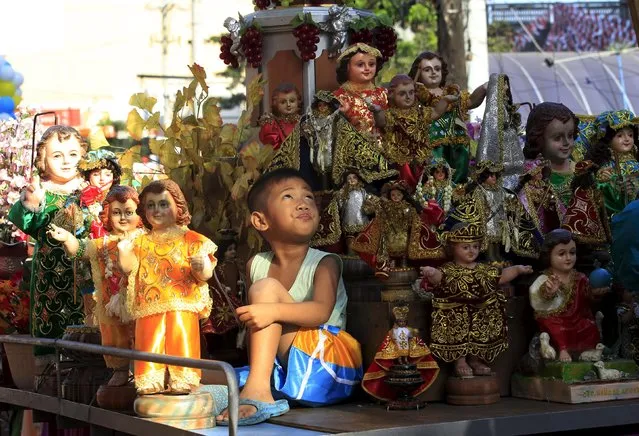 A boy looks up while surrounded by Sto. Nino (infant Jesus) replicas during a procession in Manila January 16, 2016, a day before the annual of the feast day of Sto. Nino on Sunday. (Photo by Romeo Ranoco/Reuters)