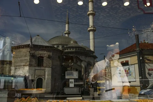 A worker prepares sweets on a pastry shop in Istiklal Street , the main shopping street of Istanbul, Friday, April 30, 2021, on the first day of a tight lockdown to help protect from the spread of the coronavirus. (Photo by Emrah Gurel/AP Photo)
