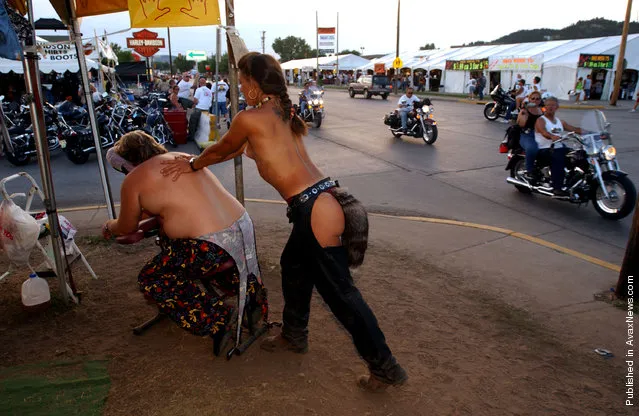 a topless woman wearing a foxtail during the 61st annual Sturgis Motorcycle...