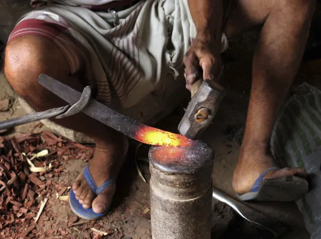 In this August 4, 2018, photo, a craftsman makes daggers or “Jambiyya” in Yemeni Arabic, made out of remains of missiles, at his workshop, in Hajjah, Yemen. (Photo by Hammadi Issa/AP Photo)