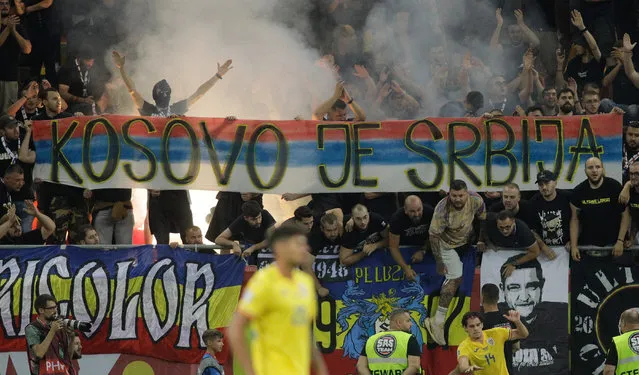 Romanian football fans hold up banners that subsequently suspended play temporarily during a Euro 2024 qualifier match between Romania and Kosovo at National Arena in Bucharest on September 12, 2023. A section of Romanian fans held up a banner that read “Kosovo is Serbia”, while some members of the home end chanted “Serbia, Serbia”, according to Reuters. (Photo by Inquam Photos via Reuters)