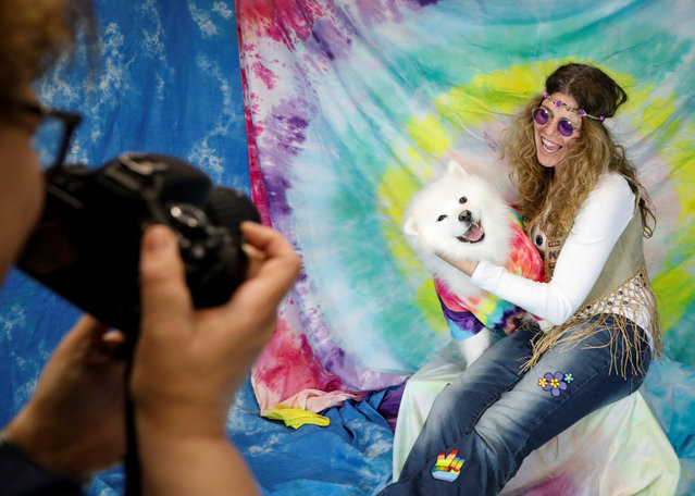 A staff members poses with a dog during a Wuffstock Halloween event, at the Morristown Animal Inn in Morristown, New Jersey on October 30, 2018. (Photo by Brendan McDermid/Reuters)