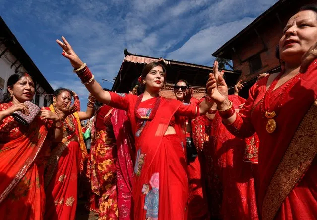 Women sing and dance at the premises of Pashupatinath Temple during the Teej festival in Kathmandu, Nepal on September 18, 2023. (Photo by Monika Malla/Reuters)