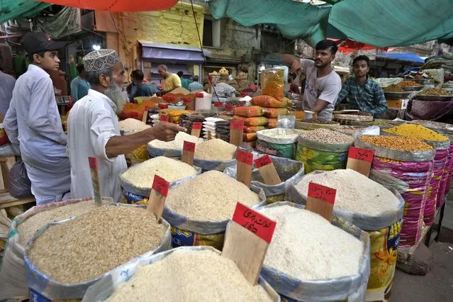 People buy rice and other items at a market, in Karachi, Pakistan, Thursday, July 13, 2023. Pakistan’s finance minister on Thursday said the International Monetary Fund deposited a much-awaited first installment of $1.2 billion with the country’s central bank under a recently signed bailout aimed at enabling the impoverished Islamic nation to avoid defaulting on its debt repayments. (Phoot by Fareed Khan/AP Photo)