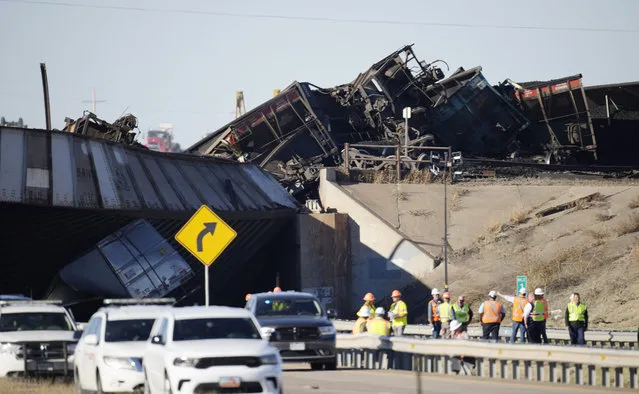 Workers toil to clear cars that derailed in an accident over Interstate 25 northbound, Monday, October 16, 2023, north of Pueblo, Colo. (Photo by David Zalubowski/AP Photo)