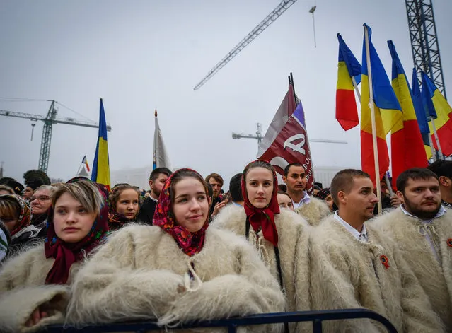 Romanian wearing traditional clothes take part in the consacration service of the Romanian People's Salvation Cathedral still under construction in Bucharest on November 25, 2018. Tens of thousands of worshippers attended the inauguration of the massive new Orthodox cathedral in Bucharest, amid criticism that public funding for the project could be better used to pay for hospitals and schools in one of the EU's poorest members. (Photo by Daniel Mihailescu/AFP Photo)
