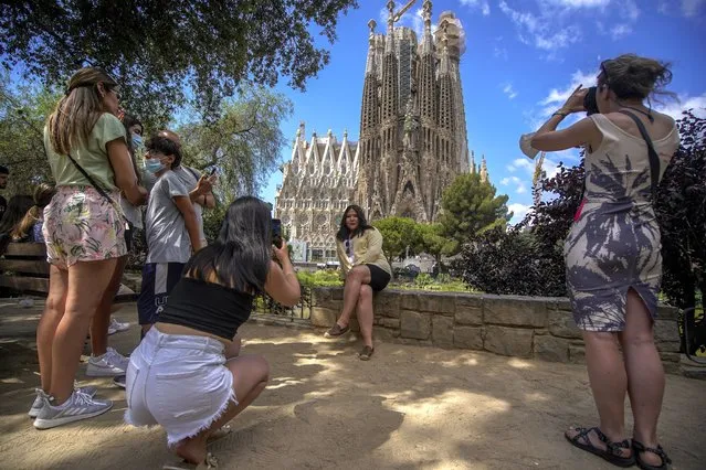 People take pictures in front of Sagrada Familia Basilica designed by architect Antoni Gaudi in Barcelona, Spain, Friday, July 9, 2021. Spain's top diplomat is pushing back against French cautions over vacationing on the Iberian peninsula. Southern Europe's holiday hotspots worry that repeated changes to rules on who can visit is putting people off travel. On Thursday, France's secretary of state for European affairs, Clement Beaune, advised people to “avoid Spain and Portugal as destinations” when booking their holidays because COVID-19 infections are surging there. (Photo by Joan Mateu/AP Photo)