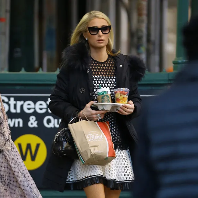TV personality Paris Hilton, wearing a black & white mesh dress, leaves her apartment carrying her breakfast of fresh fruit in New York City on December 19, 2018. (Photo by Christopher Peterson/Splash News and Pictures)