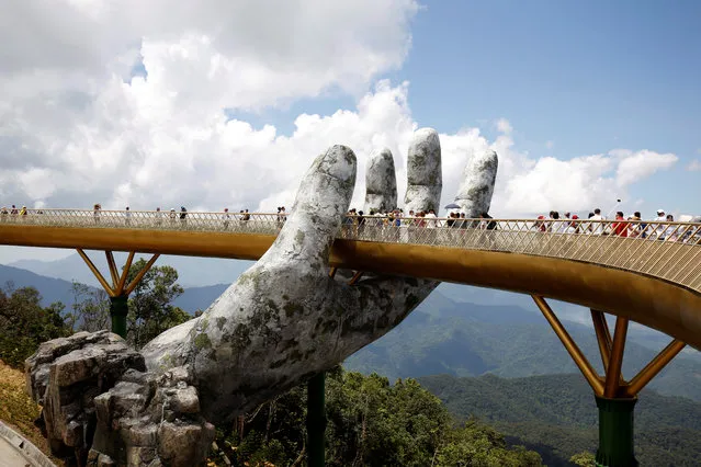 Tourists walk past a giant hand structure on the Gold Bridge on Ba Na hill near Danang City, Vietnam August 1, 2018. (Photo by Reuters/Kham)