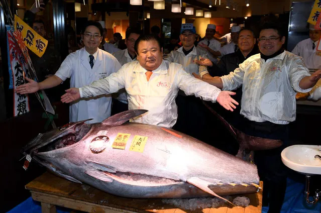 Kiyoshi Kimura (C), president of sushi restaurant chain Sushi-Zanmai,  poses with a 212-kilogram bluefin tuna at his main restaurant near the Tsukiji fish market in Tokyo on January 5, 2017. The bluefin tuna was traded at 74.2 million yen (about 632,600 USD) at the wholesale market on the first trading day of the new year. (Photo by Toshifumi Kitamura/AFP Photo)