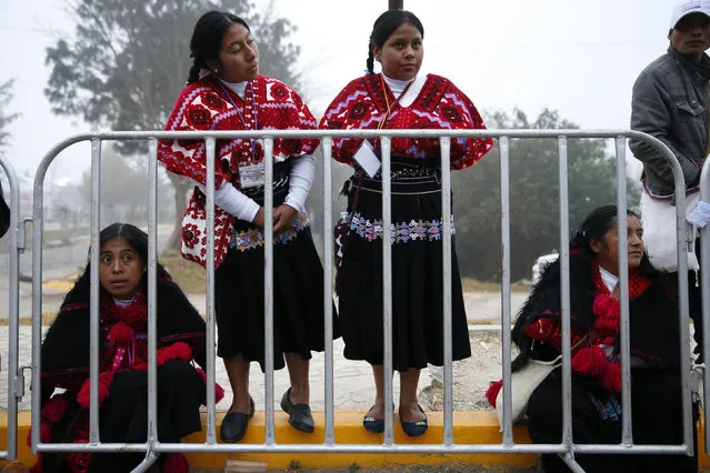 Indigenous women stand behind a barricade while waiting for Pope Francis to drive past before celebrating mass in San Cristobal de Las Casas, Mexico February 15, 2016. (Photo by Carlos Garcia Rawlins/Reuters)