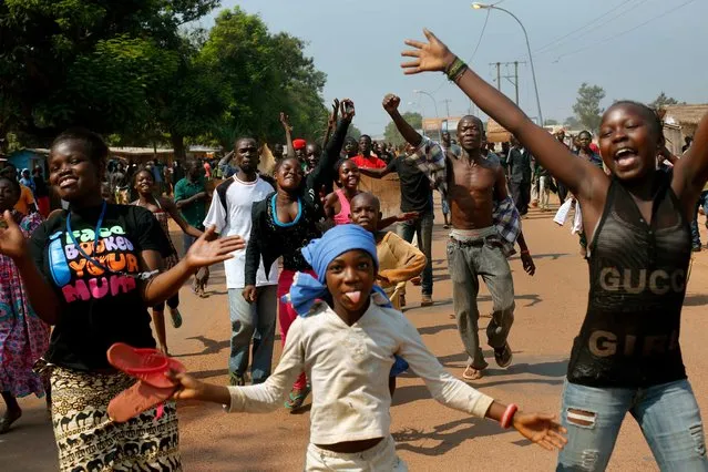 Christian youth march near the airport in Bangui, Central African Republic, calling for the resignation of the president and angry at the announced deployment of more Chadian troops within FOMAC, Friday, December 20, 2013. After a period of relative calm, violence has flared anew in the Central African Republic with angry demonstrations against Chadian peacekeepers, shootouts at checkpoints and the destruction of a mosque. (Photo by Jerome Delay/AP Photo)