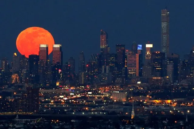 A full moon is seen as it rises over the New York City skyline seen from West Orange, N.J., Saturday, April 4, 2015. (Photo by Julio Cortez/AP Photo)