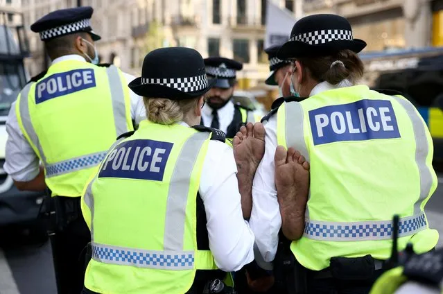 Police takes away a demonstrator during an Extinction Rebellion climate activists' protest, at Oxford Circus, in London, Britain on August 25, 2021. (Photo by Henry Nicholls/Reuters)