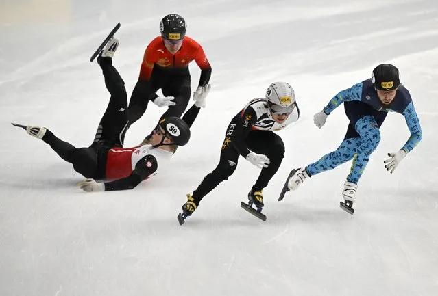 South Korea's Seo Yi-ra.(C) and Kazakhstan’s Denis Nikisha (R) compete as Poland's Michal Niewinski (L) falls during the men's 500m final at the ISU World Cup Short Track Speed Skating in Seoul on December 17, 2023. (Photo by Jung Yeon-je/AFP Photo)