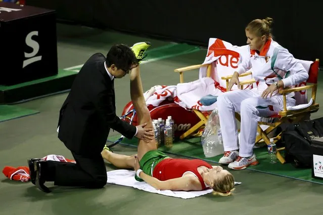 Olga Govortsova of Belarus has her leg massaged in a break during her FedCup World Group II play-off tennis match against Kurumi Nara of Japan in Tokyo April 18, 2015. Seated at R is Belarus captain Tatiana Poutchek. (Photo by Thomas Peter/Reuters)