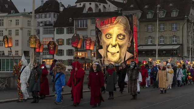 Carnival revellers wearing lanterns during the “Morgestraich” parade through the streets of Basel, Switzerland, on Monday, March 11, 2019. (Photo by Georgios Kefalas/Keystone via AP Photo)