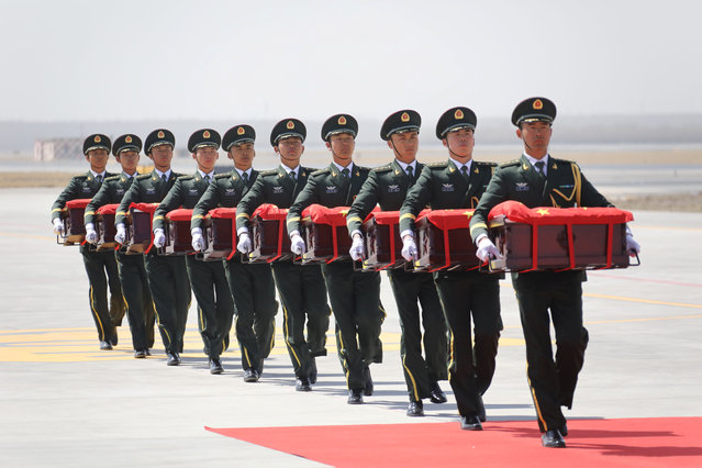 Soldiers of Chinese People's Liberation Army (PLA) carry caskets that arrived from South Korea containing remains of Chinese soldiers who fought in the Korean War, at an airport in Shenyang, Liaoning province, China April 3, 2019. (Photo by Reuters/China Stringer Network)
