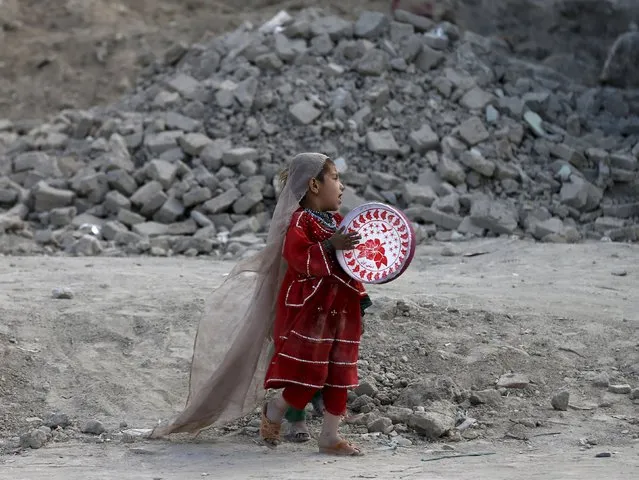 An Afghan girl plays a tambourine outside her house in Kabul, Afghanistan April 27, 2015. (Photo by Mohammad Ismail/Reuters)