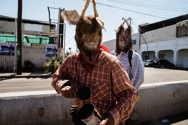 Street performers work near the fence that separates the US and Mexico in Mexicali, Mexico on April 5, 2019. (Photo by Ariana Drehsler/UPI/Barcroft Images)
