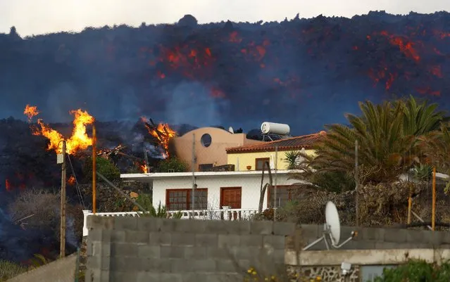 A house burns due to lava following the eruption of Cumbre Vieja Volcano, on the Canary Island of La Palma, Spain, October 27, 2021. (Photo by Borja Suarez/Reuters)