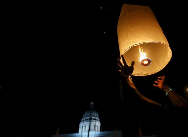 A man releases a floating lantern to mark Earth Hour in Colombo, Sri Lanka March 19, 2016. (Photo by Dinuka Liyanawatte/Reuters)