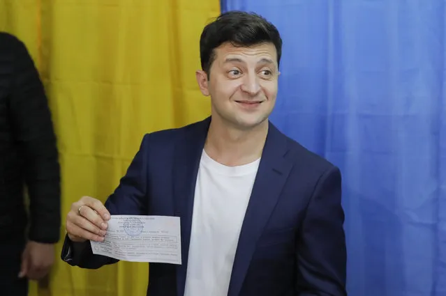 Ukrainian comedian and presidential candidate Volodymyr Zelenskiy shows his ballot before casting his ballot at a polling station, during the second round of presidential elections in Kiev, Ukraine, Sunday, April 21, 2019. Top issues in the election have been corruption, the economy and how to end the conflict with Russia-backed rebels in eastern Ukraine. (Photo by Vadim Ghirda/AP Photo)