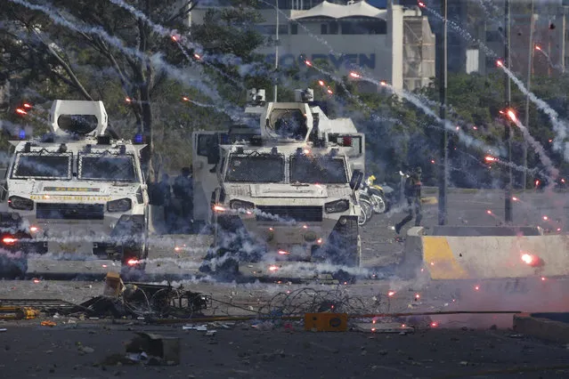 Fireworks launched by opponents of Venezuela's President Nicolas Maduro land near Bolivarian National Guard armored vehicles loyal to Maduro, during an attempted military uprising in Caracas, Venezuela, Tuesday, April 30, 2019. (Photo by Ariana Cubillos/AP Photo)