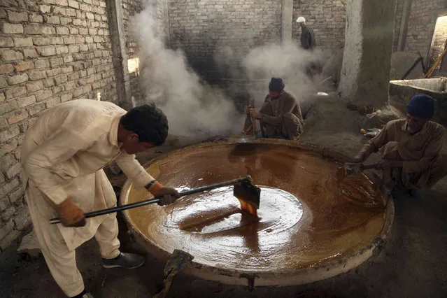 Workers produces sugarcane juice in a traditional juice factory on the outskirt of Peshawar, Pakistan, Thursday, November 4, 2021. (Photo by Mohammad Sajjad/AP Photo)