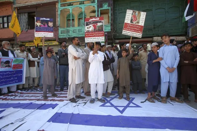 Shiite Muslims stand over the representations of U.S. and Israeli flags during the annual Al-Quds, or Jerusalem, Day demonstration in Peshawar, Pakistan, Friday, April 5, 2024. Jerusalem Day began after the 1979 Islamic Revolution in Iran, when the Ayatollah Khomeini declared the last Friday of the Muslim holy month of Ramadan a day to demonstrate the importance of Jerusalem to Muslims. (Photo by Muhammad Sajjad/AP Photo)