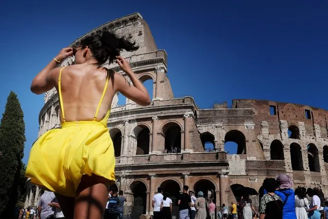 A tourist walks under the sun in front of the Colosseum in Rome on June 25, 2019 during a heatwave. Meteorologists blamed a blast of torrid air from the Sahara for the unusually early summer heatwave, which could send thermometers up to 40 degrees Celsius (104 Fahrenheit) across large swathes of the continent. (Photo by Alberto Pizzoli/AFP Photo)