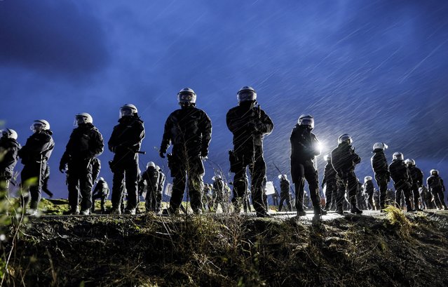 Police guard the opencast mine near the village of Luetzerath, Germany, 11 January 2023. The village of Luetzerath in North Rhine-Westphalia state is to make way for lignite mining despite the decision to phase out coal. The Garzweiler open pit mine, operated by German energy supplier RWE, is at the focus of protests by people who want Germany to stop mining and burning coal as soon as possible in the fight against climate change. (Photo by Ronald Wittek/EPA/EFE)