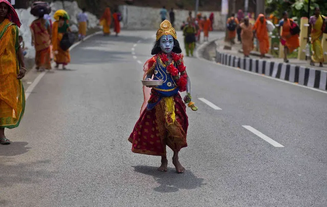 A boy dressed as Hindu goddess Kali asks for alms on a road near the Kamakhya Hindu temple ahead of the Ambubachi festival in Gauhati, India, Friday, June 21, 2019. (Photo by Anupam Nath/AP Photo)