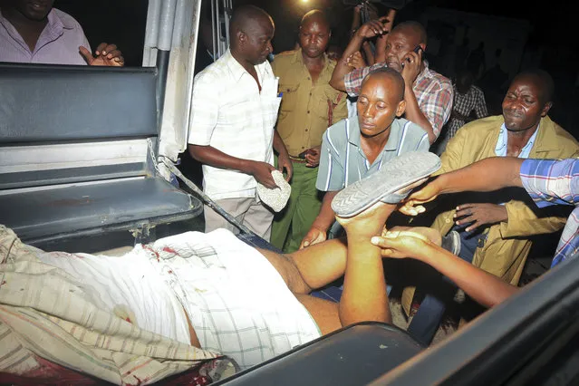 Kenyan police put the lifeless body of slain Muslim cleric Abubakar Shariff Ahmed into the back of a police pickup truck on a highway in Mombasa, Kenya, Tuesday, April 1, 2014. (Photo by AP Photo)