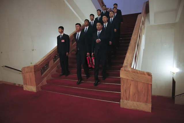 In this Friday, March 10, 2017 photo, soldiers in usher uniforms, some carry fire extinguishers march down a staircase after the Chinese People's Political Consultative Conference (CPPCC) at the Great Hall of the People in Beijing. Because safety comes first, fire extinguishers are ubiquitous in and around Beijing’s Great Hall of the People during the annual sessions of China’s ceremonial parliament and its official advisory body. That’s partly for standard purposes of preventing any sort of fire-related emergency that could harm the participants and mar the proceedings. (Photo by Andy Wong/AP Photo)