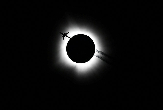 An airplane passes near the total solar eclipse during the Hoosier Cosmic Celebration at Memorial Stadium in Bloomington, Indiana on April 8, 2024. (Photo by Bobby Goddin/USA Today Network)