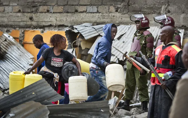 Residents retrieve some of their remaining belongings after a mechanical digger demolished their homes, close to the site of last week's building collapse, after the homes were deemed unfit for habitation and they were evicted, in the Huruma neighborhood of Nairobi, Kenya Friday, May 6, 2016. (Photo by Ben Curtis/AP Photo)