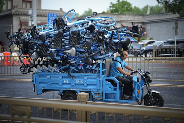 A worker transports share bikes to a tourist destination in downtown Beijing, China, Saturday, June 29, 2024. (Photo by Vincent Thian/AP Photo)