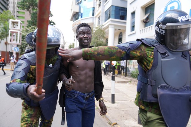 Kenyan riot police arrest a man during a protest over proposed tax hikes in a finance bill in downtown Nairobi, Kenya Tuesday, June. 25, 2024. (Photo by Brian Inganga/AP Photo)